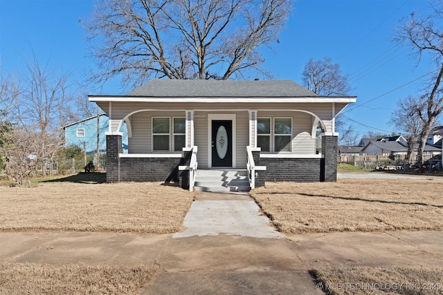 bungalow-style home with a porch and a front lawn