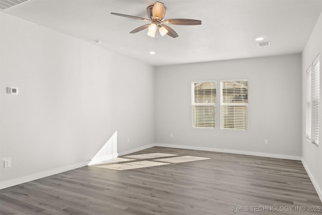 spare room with dark wood-type flooring and ceiling fan