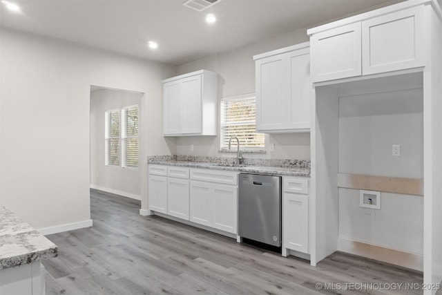 kitchen with sink, dishwasher, white cabinetry, light stone counters, and a healthy amount of sunlight