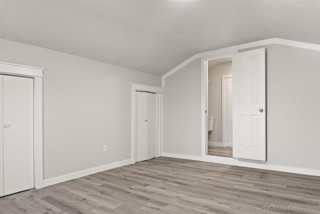 additional living space featuring vaulted ceiling and light hardwood / wood-style floors