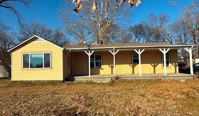 single story home featuring covered porch and a front lawn