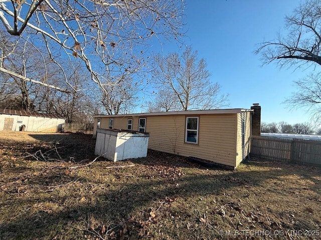 back of property with a storage shed