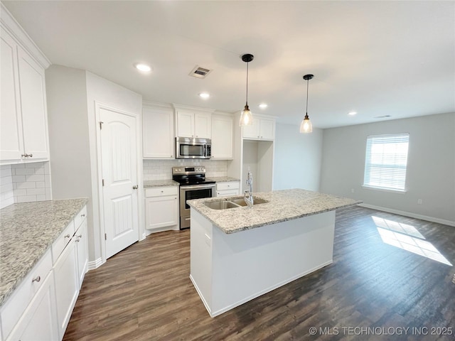 kitchen with white cabinetry, an island with sink, sink, stainless steel appliances, and light stone countertops