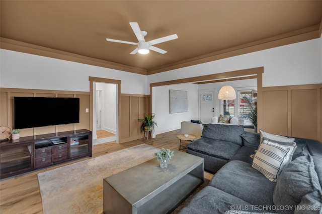304 E Dallas St, Broken Arrow, OK 74012 - living area featuring a decorative wall, a ceiling fan, wood finished floors, and wainscoting