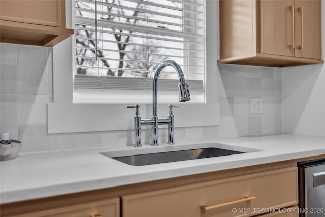 details featuring sink, backsplash, stainless steel dishwasher, and light brown cabinets