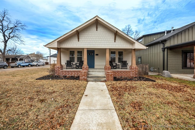 bungalow-style home featuring a porch and a front yard