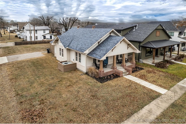 view of front facade featuring covered porch and a front yard