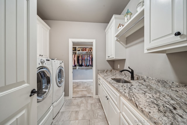 washroom featuring separate washer and dryer, sink, and cabinets