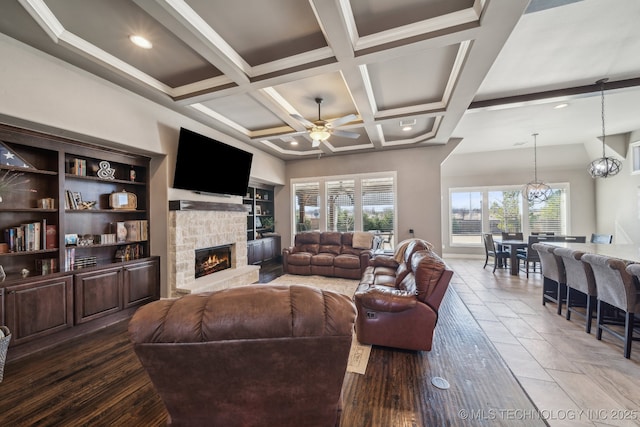 living room featuring coffered ceiling, ceiling fan, a fireplace, and beam ceiling