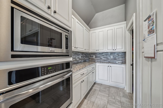 kitchen with light stone counters, backsplash, stainless steel appliances, and white cabinets