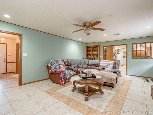 tiled living room featuring a textured ceiling and ceiling fan