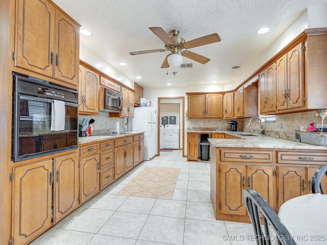 kitchen featuring washer / dryer, sink, white fridge, oven, and decorative backsplash