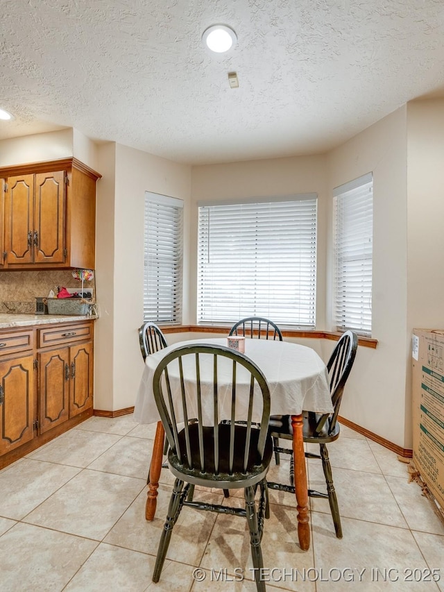 tiled dining room with a textured ceiling