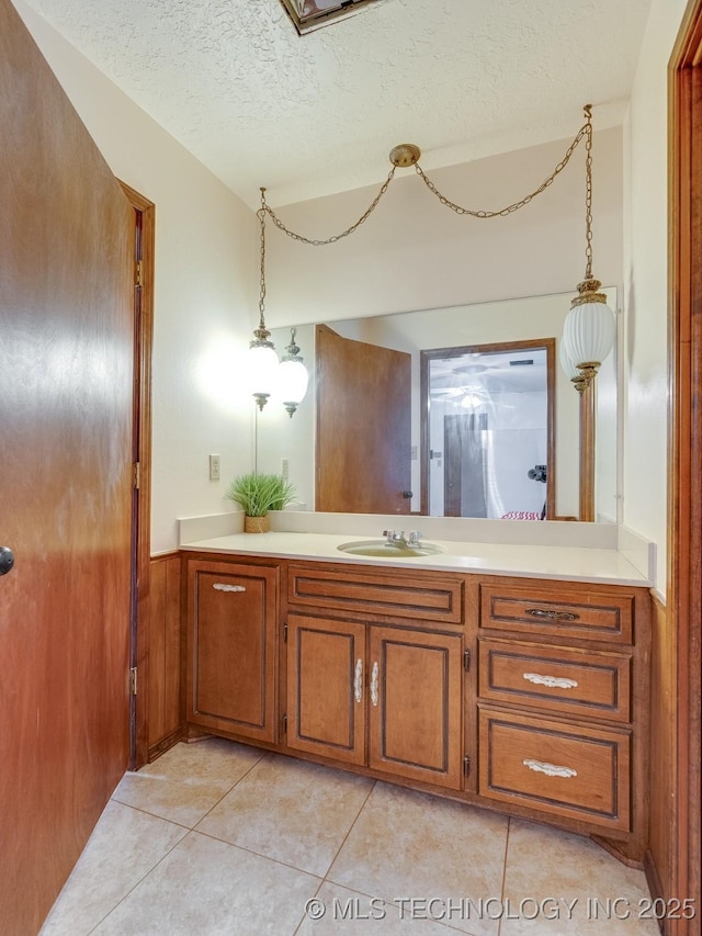 bathroom featuring tile patterned flooring, vanity, and a textured ceiling