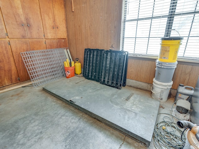 misc room featuring wooden walls and concrete floors