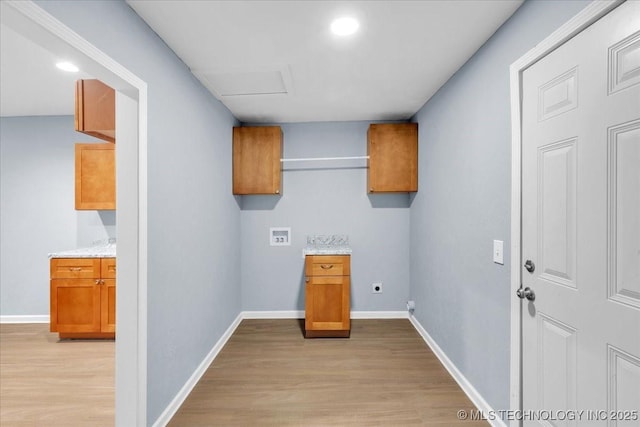 clothes washing area featuring cabinets, electric dryer hookup, hookup for a washing machine, and light wood-type flooring