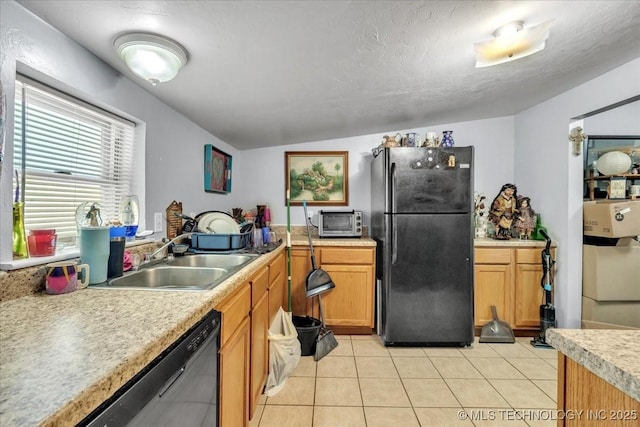 kitchen with light tile patterned floors, sink, a textured ceiling, and black appliances