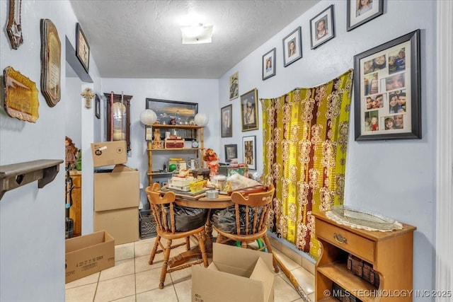 tiled dining space featuring a textured ceiling