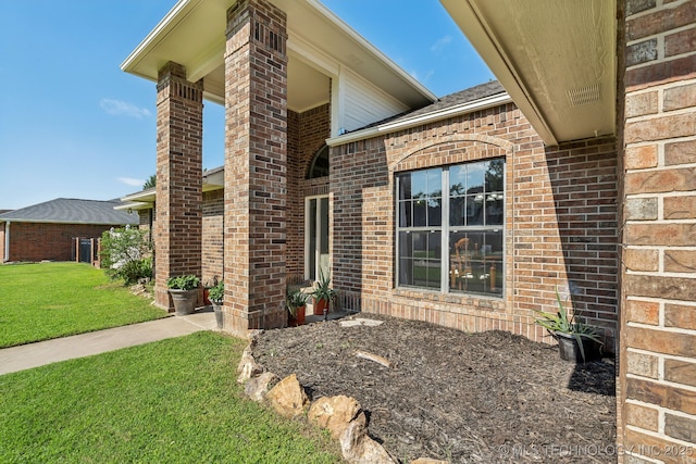 view of exterior entry with a yard