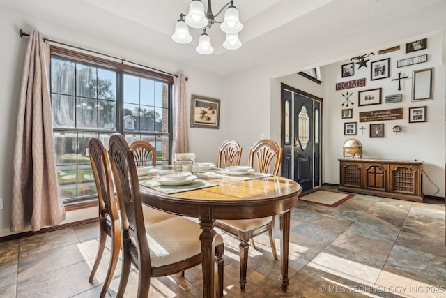 dining area featuring a notable chandelier and a tray ceiling