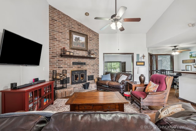 living room with ceiling fan, high vaulted ceiling, and a brick fireplace