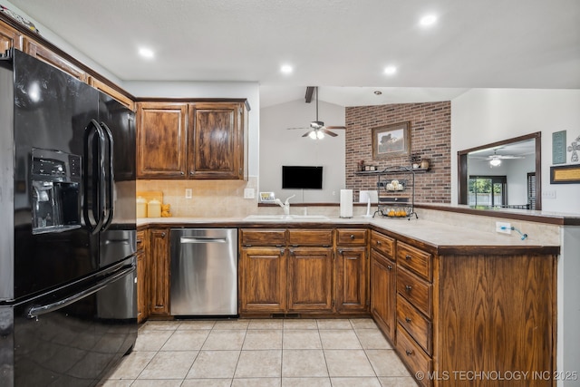 kitchen with vaulted ceiling, sink, stainless steel dishwasher, kitchen peninsula, and black fridge