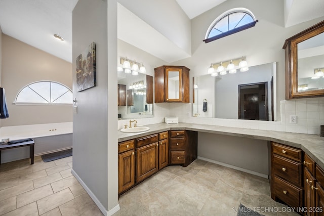 bathroom featuring vanity, backsplash, plenty of natural light, and high vaulted ceiling