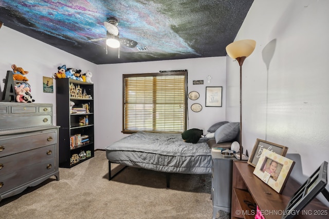 carpeted bedroom featuring ceiling fan and a textured ceiling