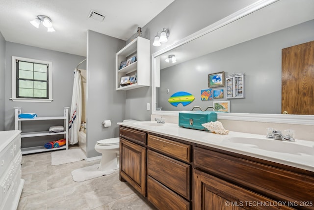 full bathroom with vanity, shower / bath combo, and toilet