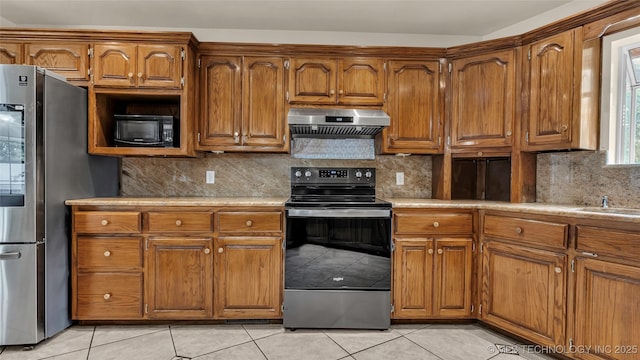 kitchen featuring electric stove, light tile patterned floors, stainless steel fridge, and range hood