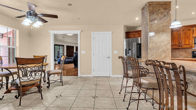 kitchen featuring tasteful backsplash, decorative light fixtures, stainless steel fridge with ice dispenser, light tile patterned floors, and ceiling fan