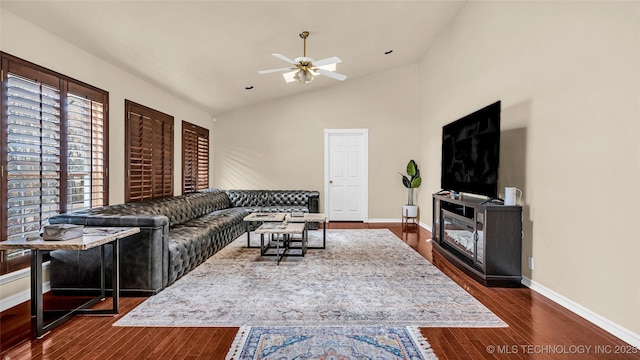 living room featuring high vaulted ceiling, dark wood-type flooring, and ceiling fan