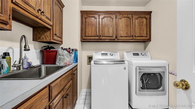 washroom with cabinets, sink, and washer and dryer