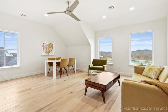 living room with lofted ceiling, ceiling fan, and light hardwood / wood-style flooring