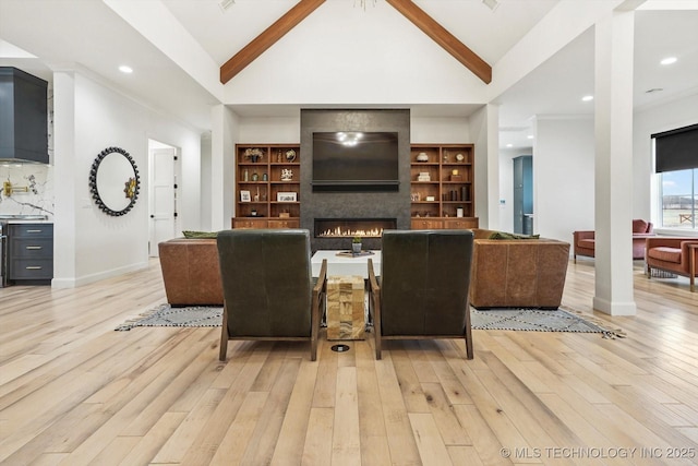 living room with beam ceiling, high vaulted ceiling, a fireplace, and light hardwood / wood-style floors