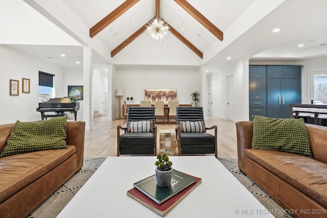 living room with beamed ceiling, high vaulted ceiling, an inviting chandelier, and light hardwood / wood-style floors