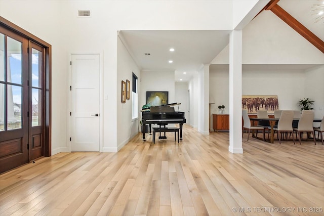 foyer entrance featuring a high ceiling and light hardwood / wood-style flooring