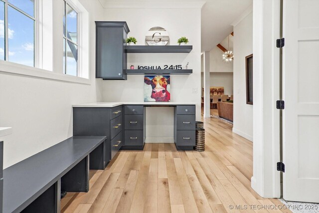 office space with ornamental molding and light wood-type flooring