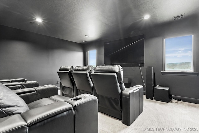 home theater room featuring light carpet and a textured ceiling