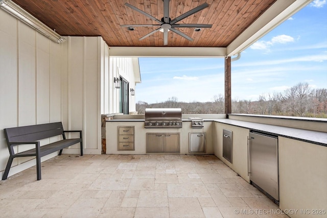 view of patio / terrace with ceiling fan, grilling area, and exterior kitchen