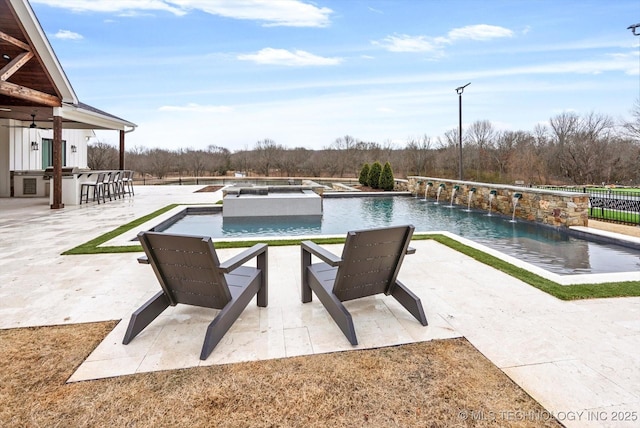 view of pool featuring a patio area, an in ground hot tub, pool water feature, and exterior bar