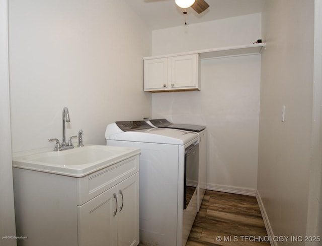 laundry room with sink, cabinets, washing machine and clothes dryer, ceiling fan, and dark wood-type flooring