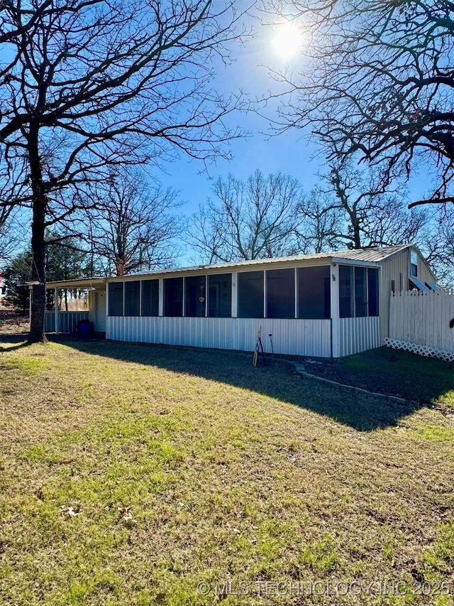 rear view of property with a yard and a sunroom