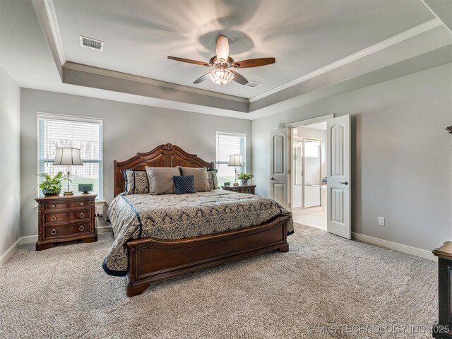 bedroom with light colored carpet, ornamental molding, and a tray ceiling