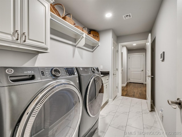 clothes washing area with visible vents, baseboards, marble finish floor, independent washer and dryer, and cabinet space