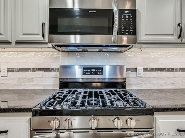 details with appliances with stainless steel finishes, dark countertops, and backsplash