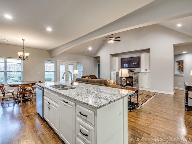 kitchen featuring a kitchen island with sink, sink, white cabinetry, and dishwasher