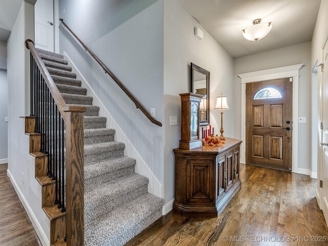 entryway featuring stairs, baseboards, and wood finished floors