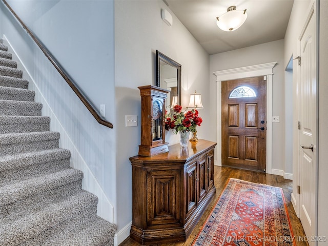 entrance foyer featuring baseboards, stairway, and dark wood finished floors