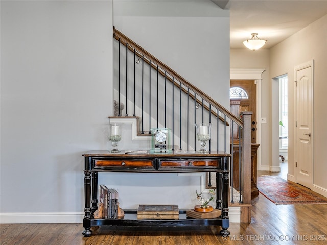 entrance foyer with baseboards, stairway, and wood finished floors